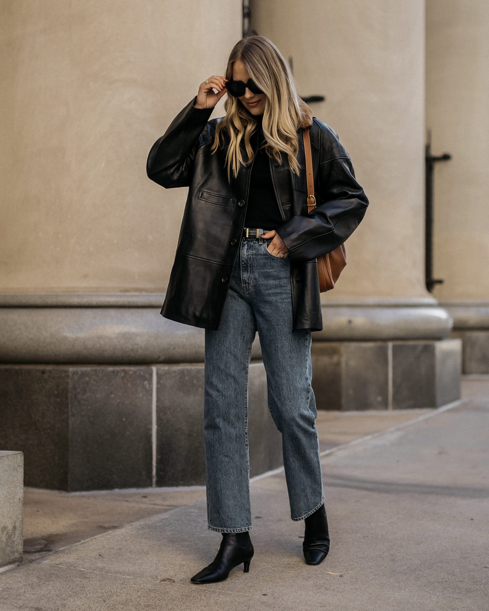 Black blazer over a dark top, cropped blue jeans and black ankle boots