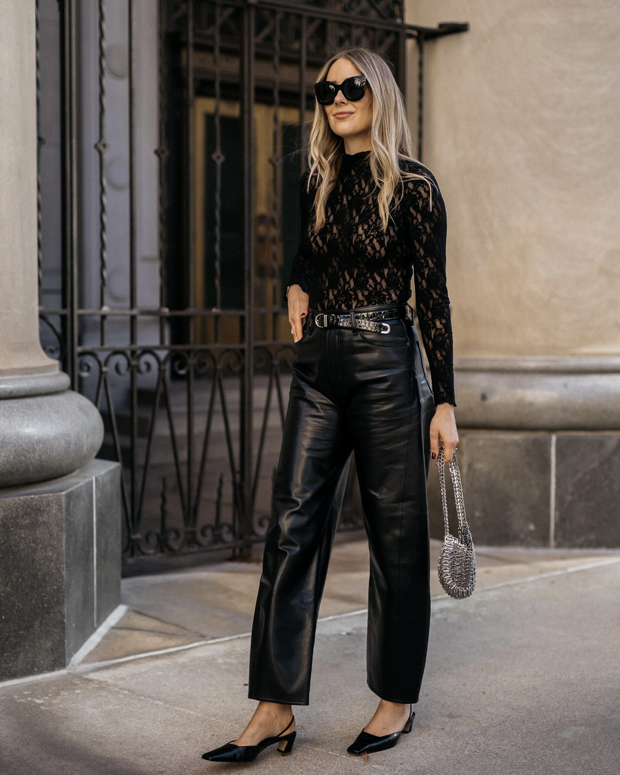 Black lace top with cropped black leather trousers and dark pointed shoes